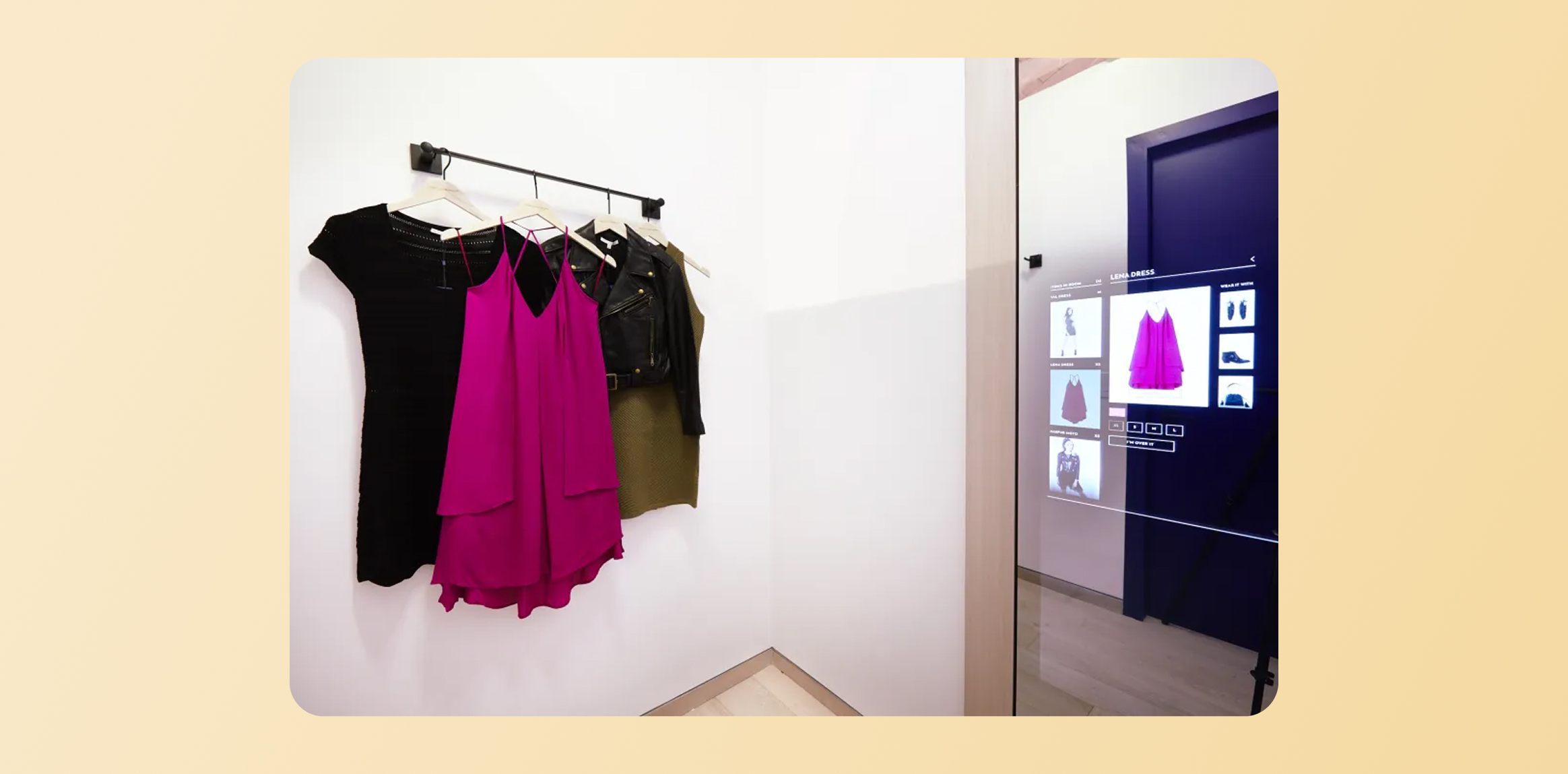 Clothes hanging on a rack&mdash;black, bright pink, and beige garments&mdash;against a white wall, with a touchscreen fashion display on the right side.